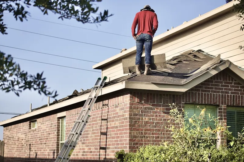 Professional roofer working on a residential roof in Whitfield